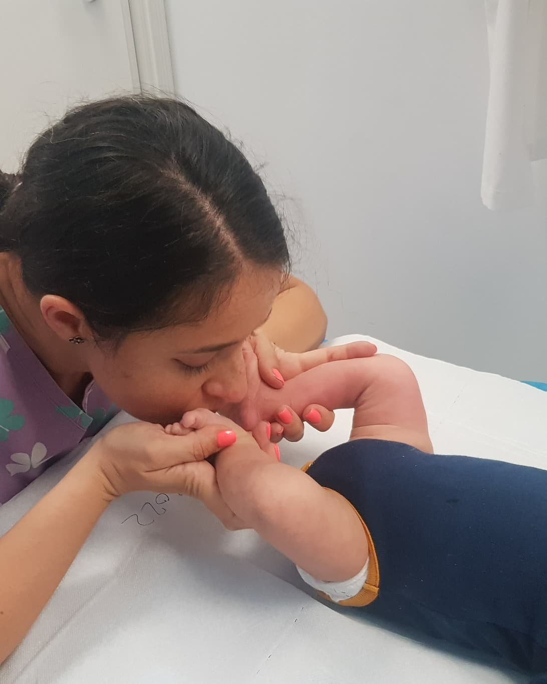 Dr. Yasmin Al-Hiary examinând piciorul unui copil în timpul consultației