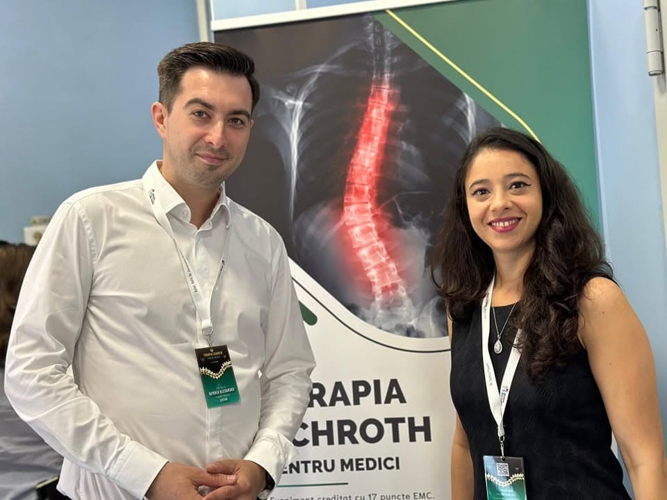 Dr. Yasmin Al-Hiary la cursul „Terapia Schroth pentru medici”, lângă afișul cu radiografia unei coloane cu scolioză